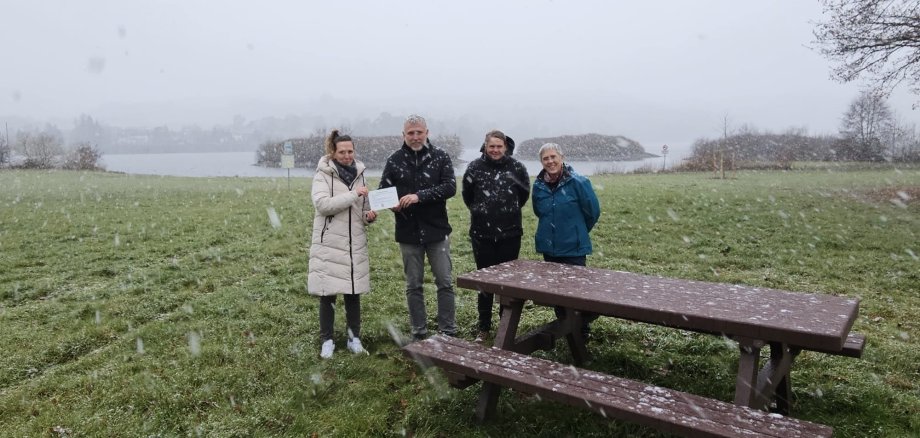 Bürgermeister Marco Herrmann, Fachbereichsleiterin Christine Nadler und die Vertreterinnen des Naturparks Lahn-Dill-Bergland Marion Klein und Eva Weil, bei Schneetreiben am Aartalsee.